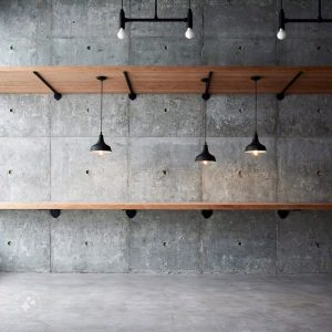 Minimalist brutalist interior design featuring raw concrete walls, exposed structural elements, and simple, functional furniture with clean lines, creating an industrial yet modern aesthetic.