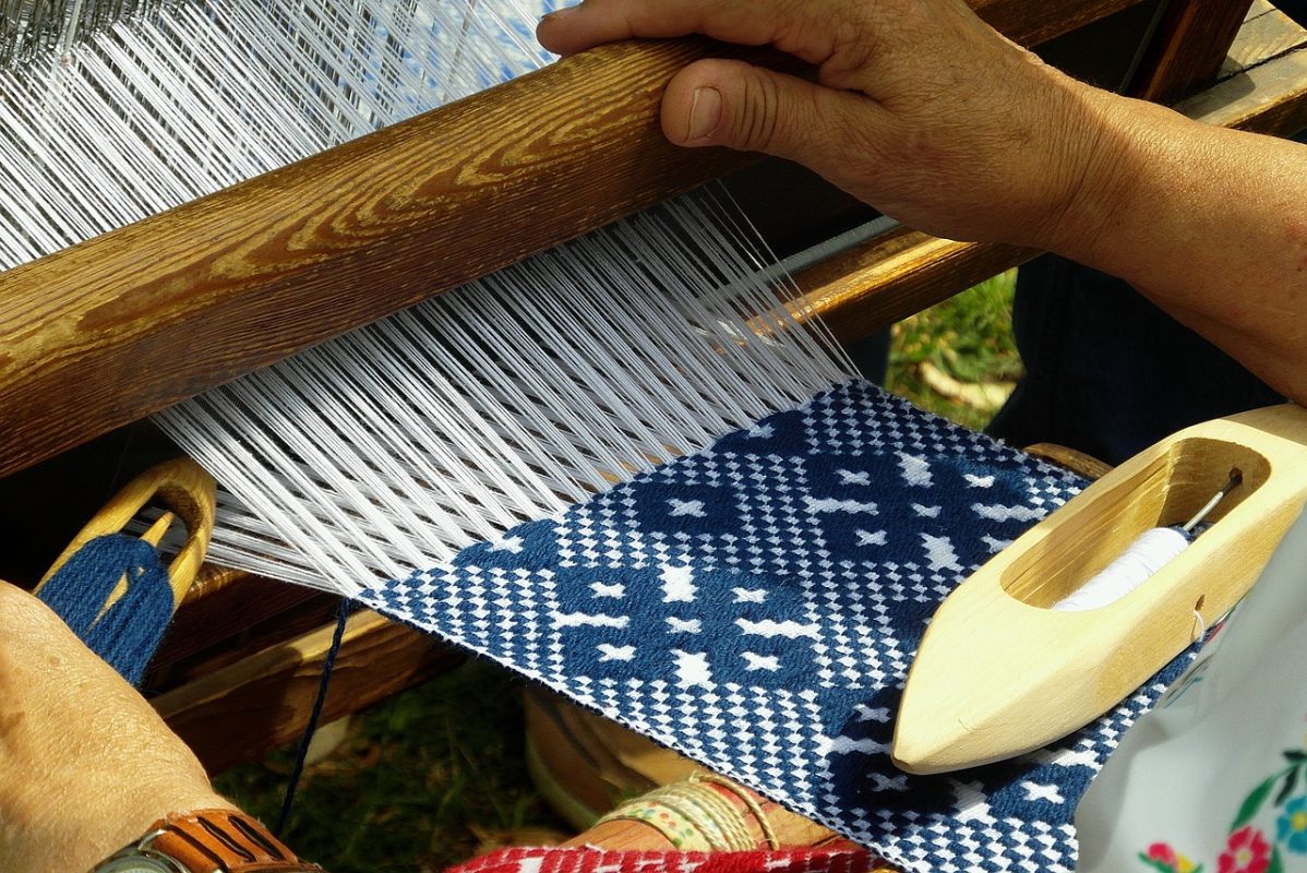 Traditional Al Sadu weaving technique demonstrated by a Bedouin woman on a ground loom