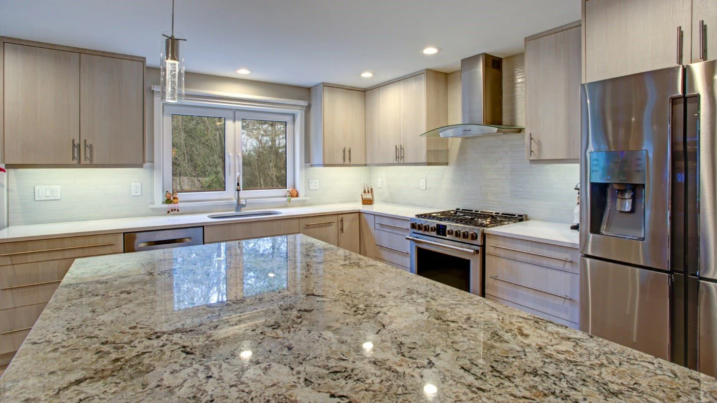 Modern L-shaped kitchen with granite island and stainless steel appliances