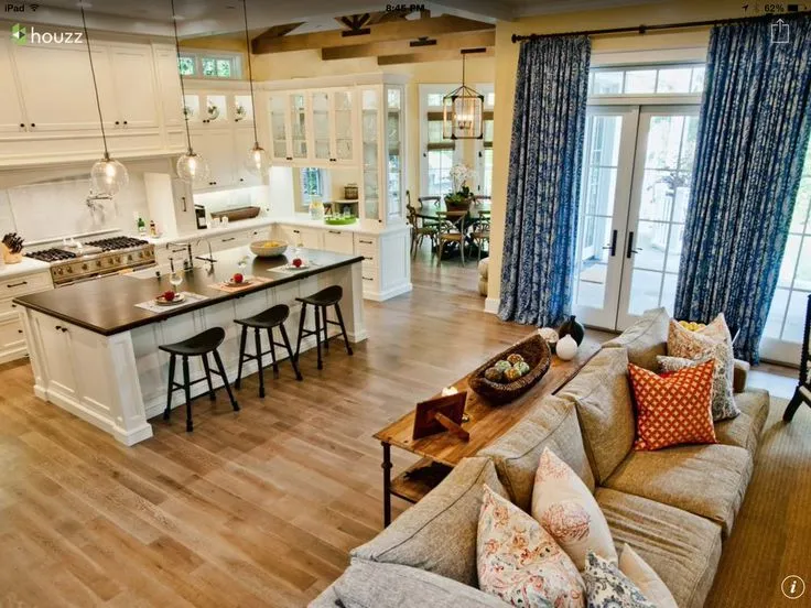 Cozy open kitchen with white cabinetry, pendant lights, and island