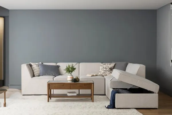 Modern living room, sectional L-Shaped Sofa, built-in storage, gray wall.