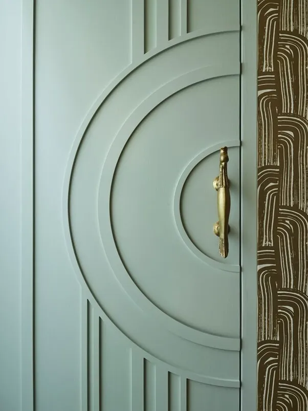 Art Deco door, circular design, gold pull, patterned wall.