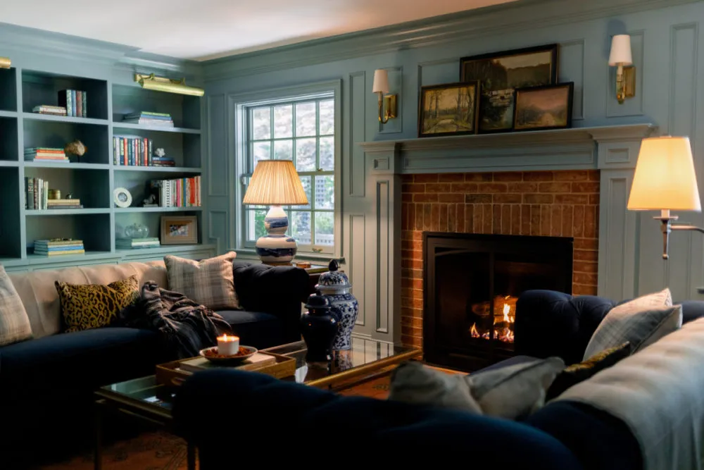 Cozy traditional bedroom with a fireplace and warm lighting.