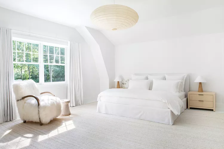 Minimalist white bedroom with a serene bedroom wall color combination.