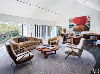 Beige living room with curved sofa and art wall with light room design