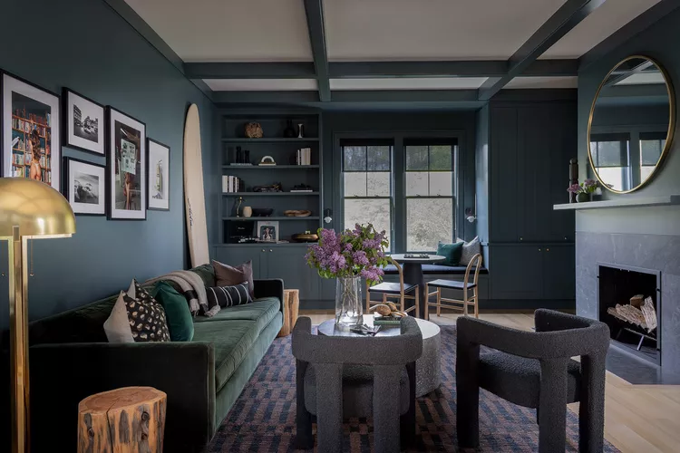 Dark cozy bedroom with deep green walls and modern decor.