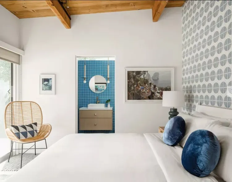 Modern minimalist bedroom with blue-tiled en-suite bathroom