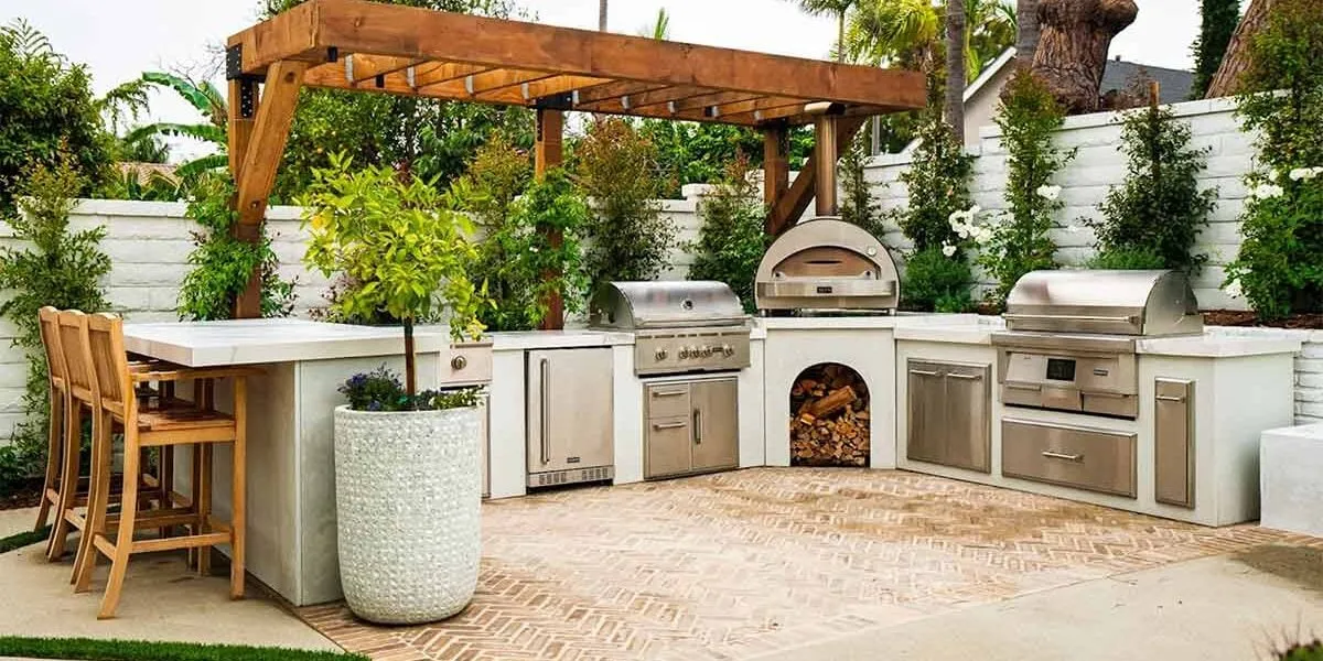 Modern outdoor kitchen with pergola, grill, and seating area