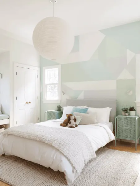 Pastel bedroom with geo wall art and white bed in a light room design