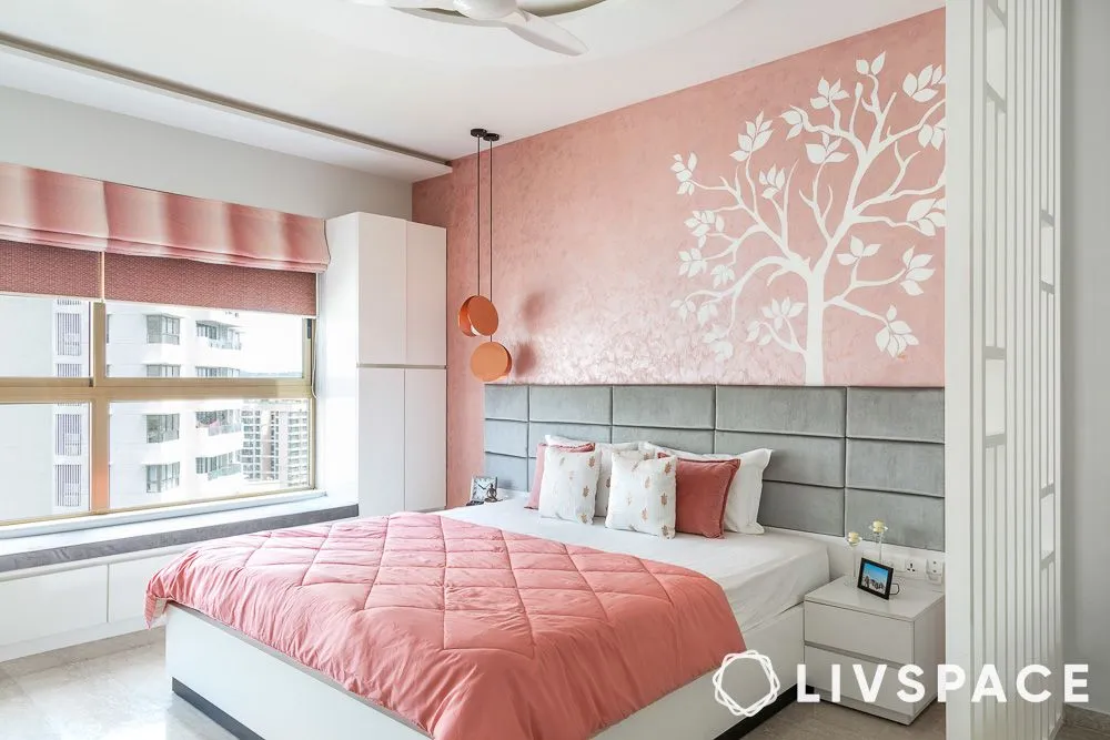 Pink bedroom with modern tree wall painting design in light hues.