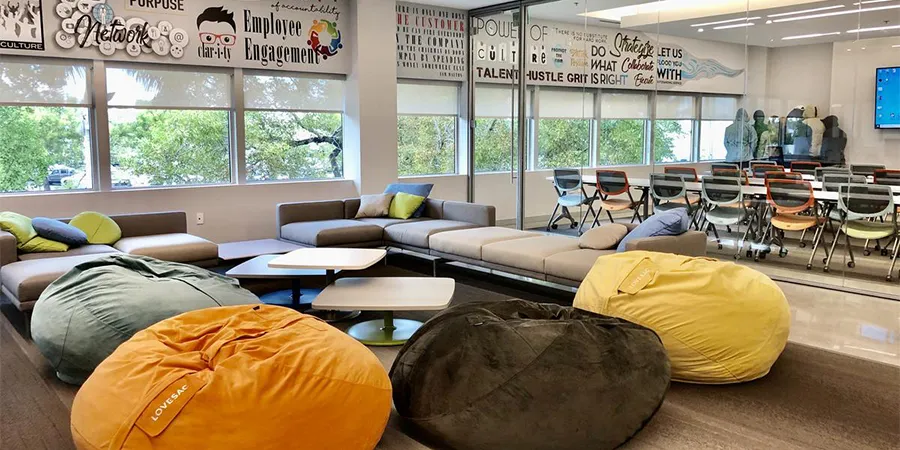 Co-working room with beanbags, meeting table, and wall graphics.