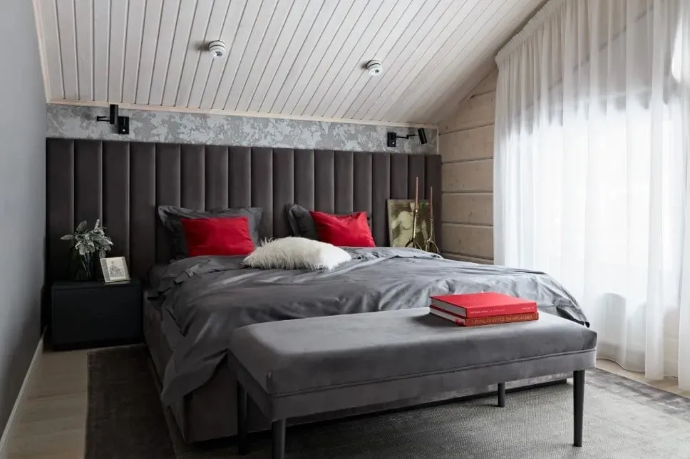 Modern attic bedroom with dark tones and cozy decor elements.