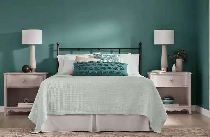 teal bedroom with bed and matching tables 