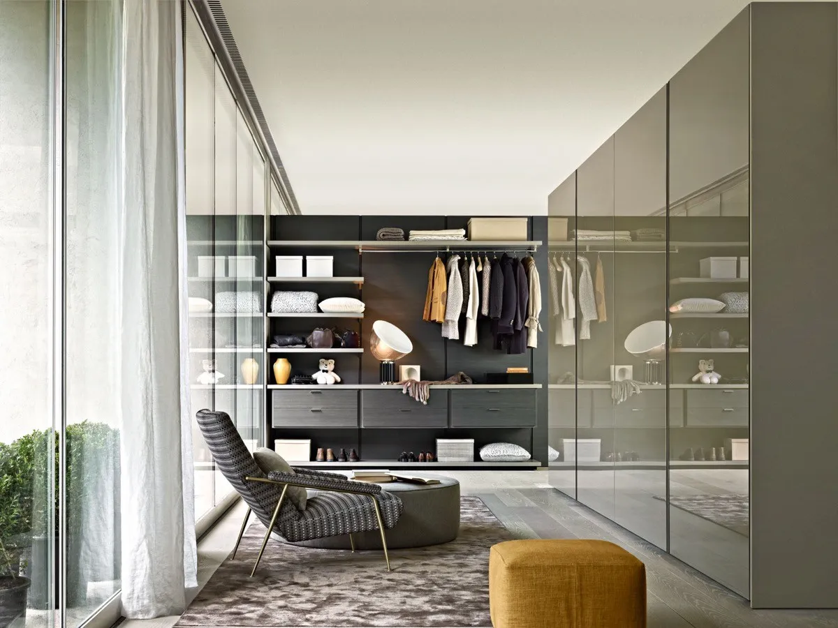 Modern walk-in wardrobe with open shelves, dark finishes, and display items.