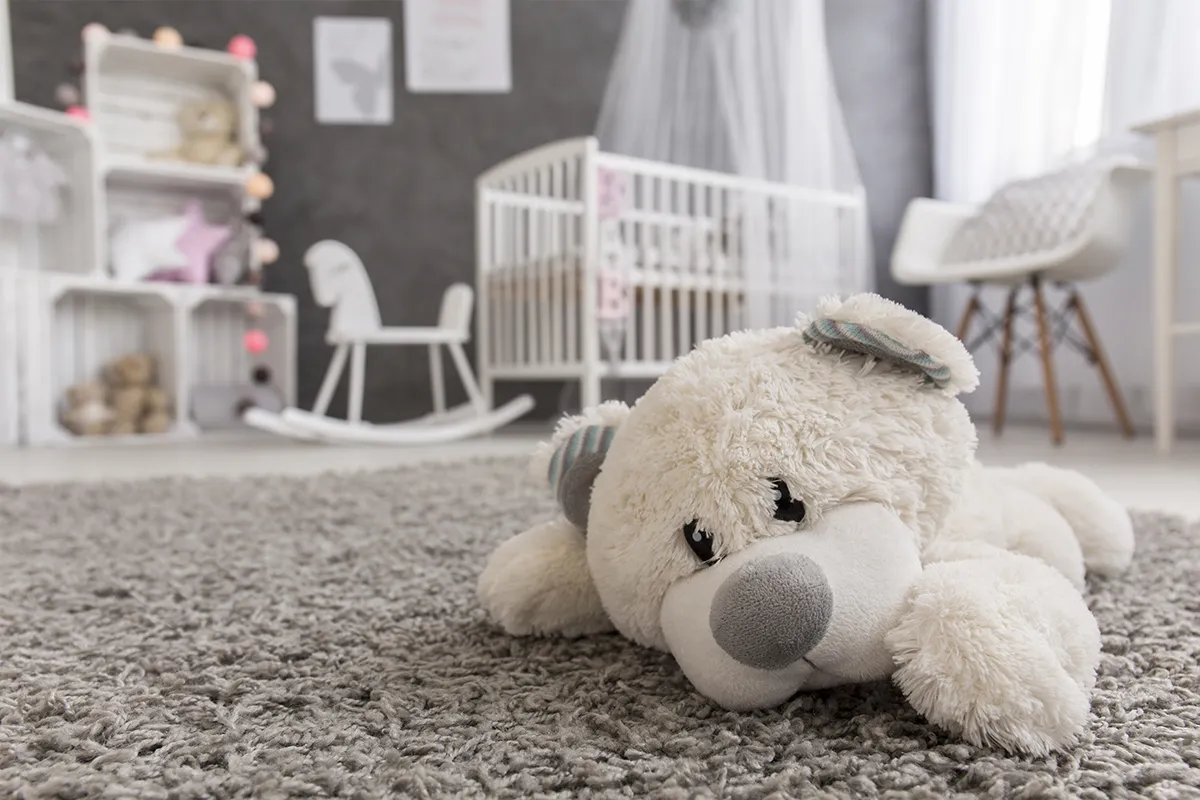 Cozy nursery room with plush teddy and soft rug for comfort