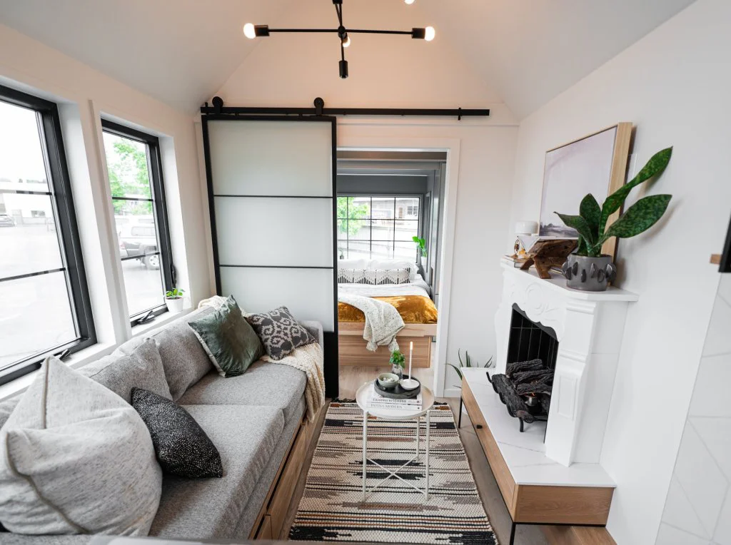  Small living room gray sofa barn door white fireplace