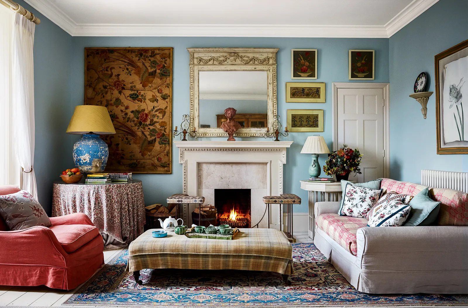 Small living room blue walls patterned sofa fireplace.