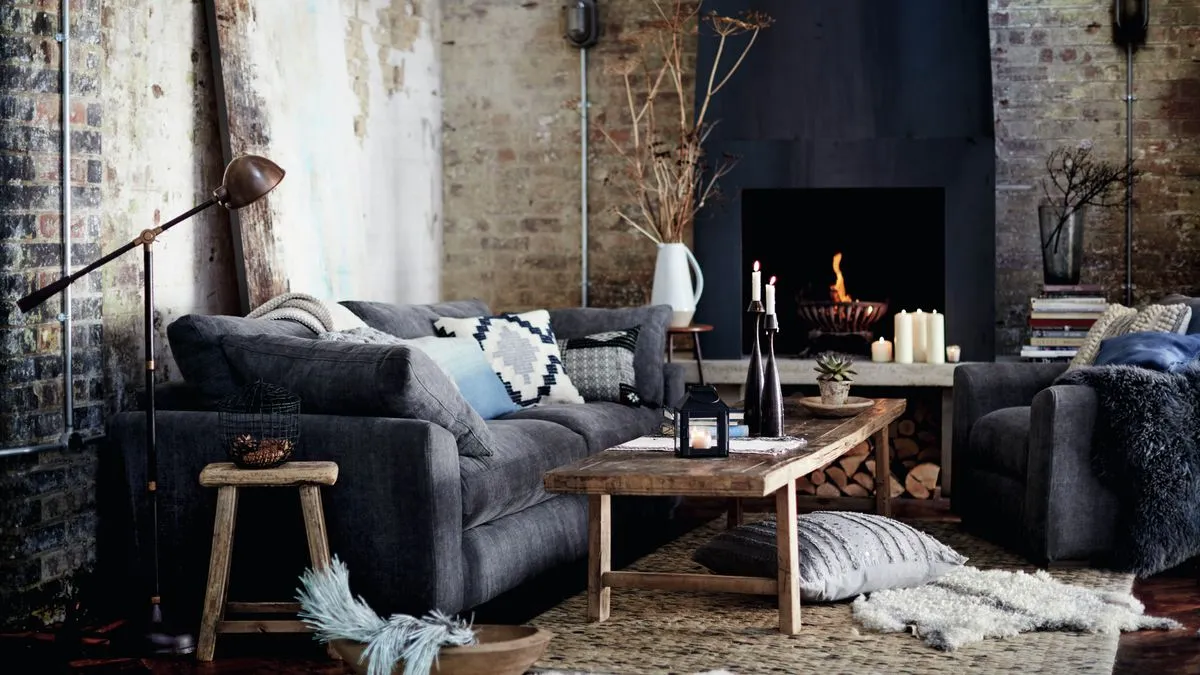 Small living room gray sofa wood table brick wall fire